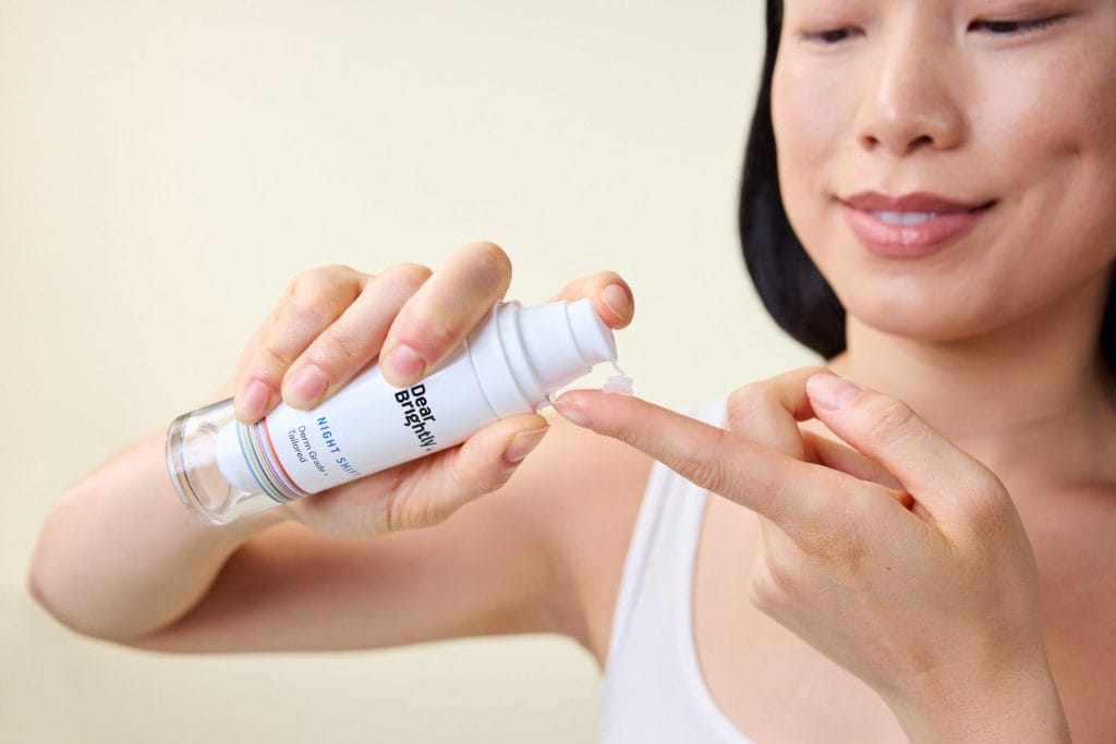 A person dispenses safe and effective skincare lotion from a pump bottle onto their finger.